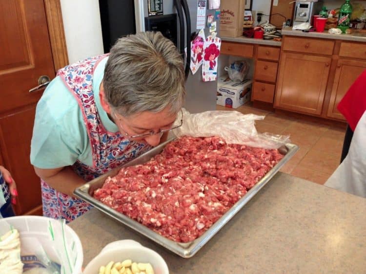 A person sitting at a table with a plate of food, with Sausage