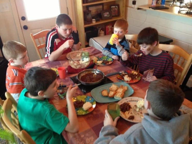 A group of people sitting at a table eating food, with Beef and Barbecue