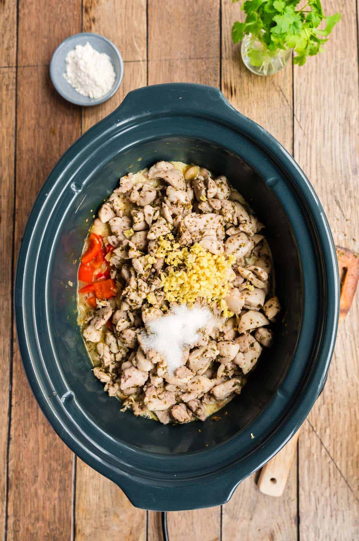 Some chicken and other ingredients in a crock pot.