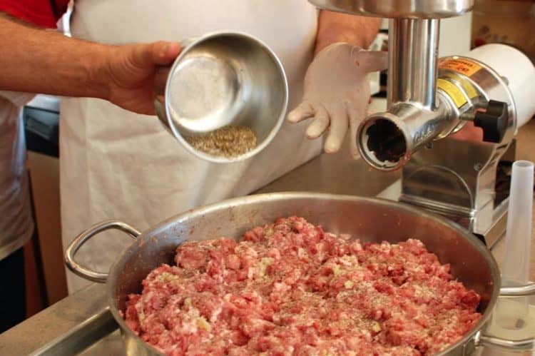 A person preparing food in a pan on a stove, with Grandparent and Kielbasa