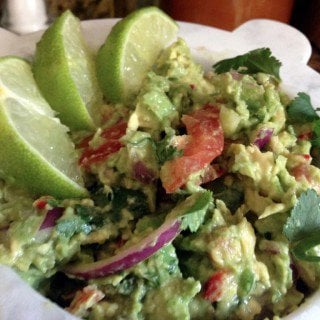 Bowl of Guacamole with limes.