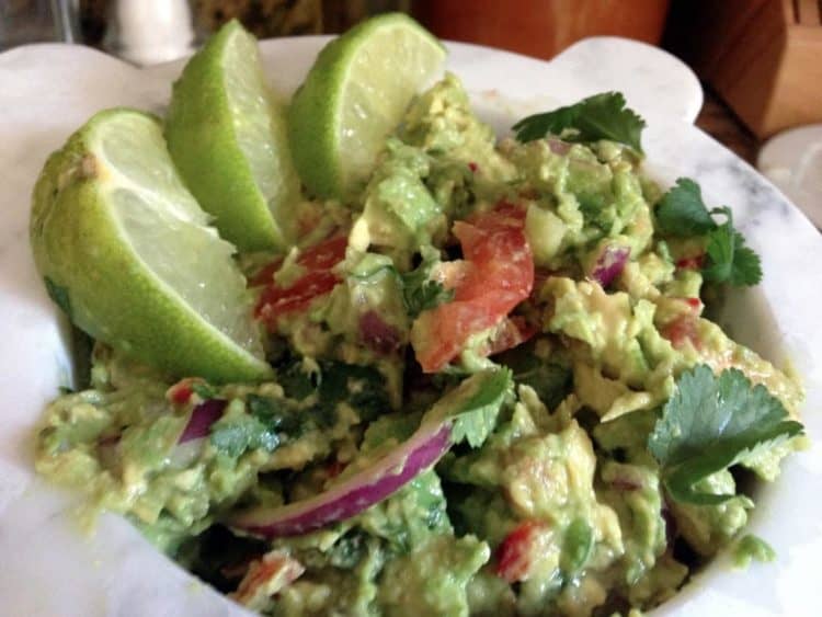 Bowl of Guacamole with limes.