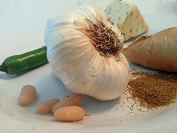 A whole clove of garlic on a plate.