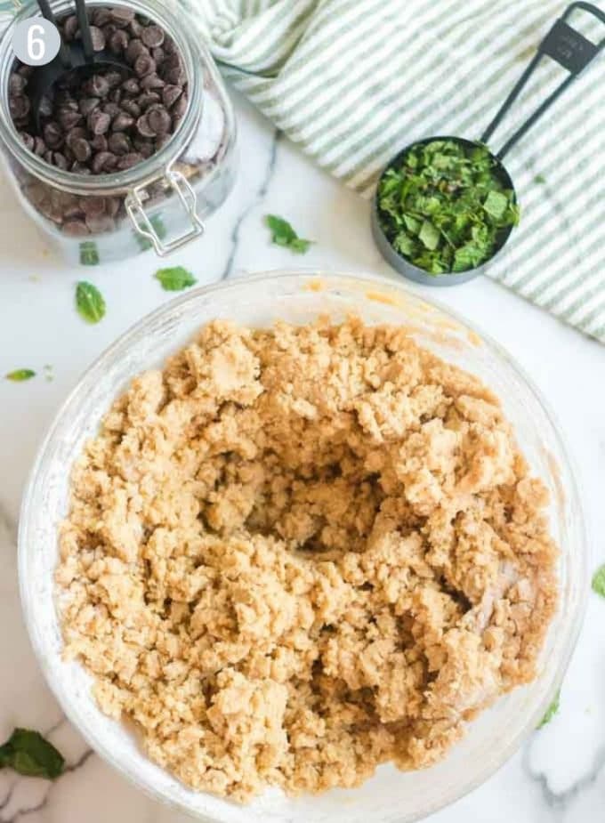  A mixing bowl of cookie dough and jar of chocoate chips