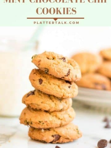 stack of chocolate chip cookies with glass of milk and fresh mint.