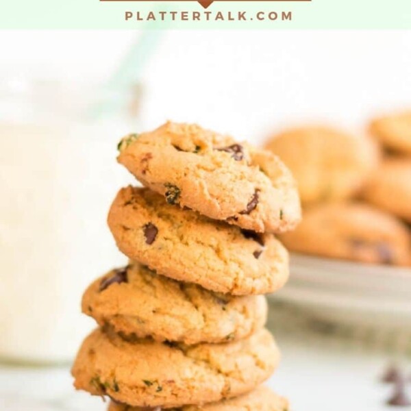 stack of chocolate chip cookies with glass of milk and fresh mint.