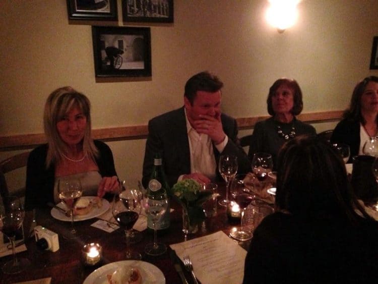 A group of people sitting at a table with wine glasses