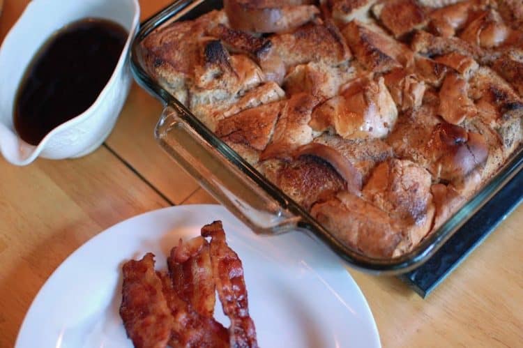 A plate of food on a table with bacon and maple syrup