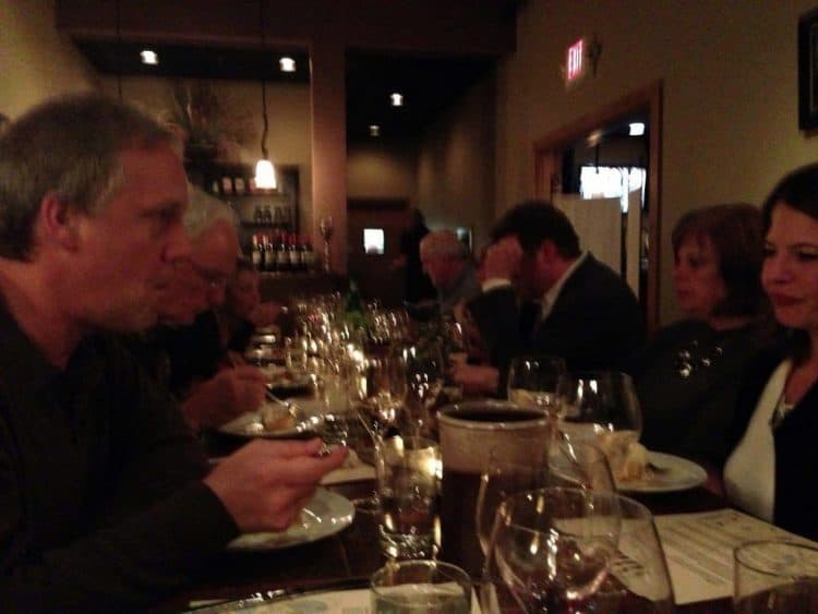 A group of people sitting at a table with wine glasses