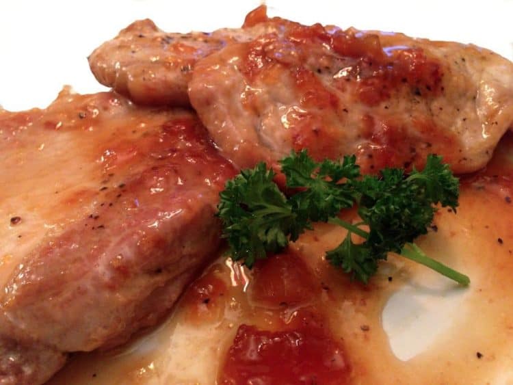 A close up of a plate of food, with Pork chop