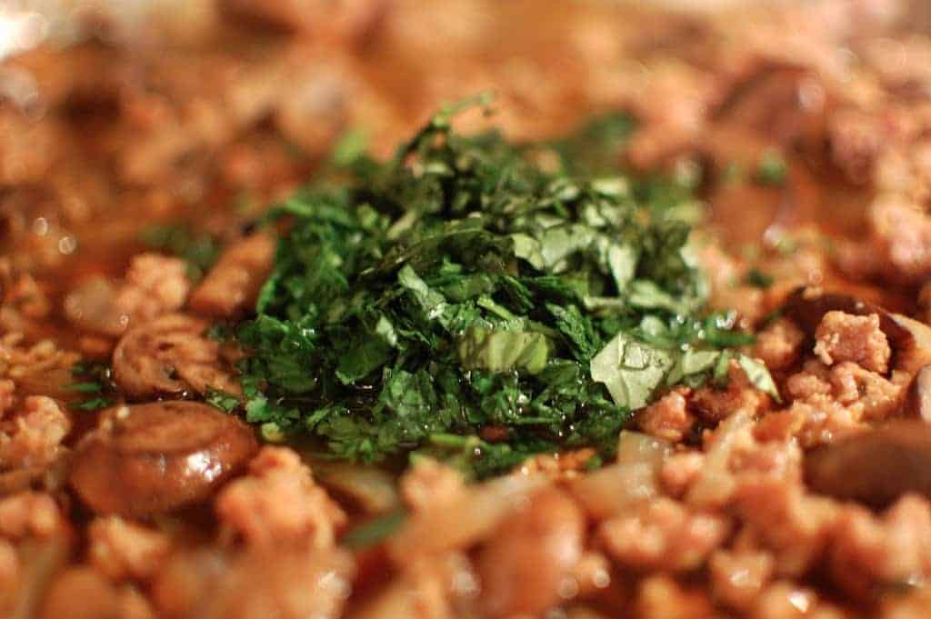 A closeup of food with chopped herbs in the center