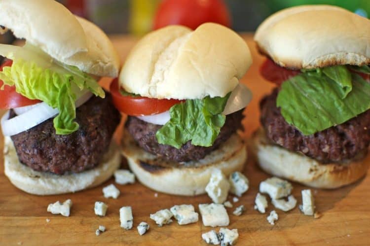A trio of hamburger sliders filled with blue cheese.