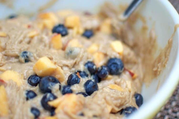 A close up of muffin batter with blueberries