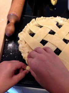 A pair of hands crimping a pie crust