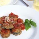A plate of food with baked eggplant.