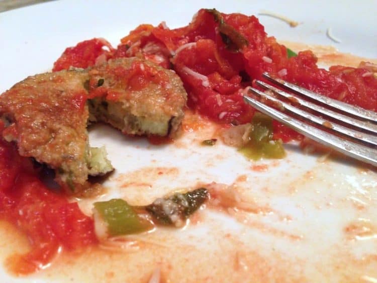 A close up of a plate of food eggplant and tomatoes