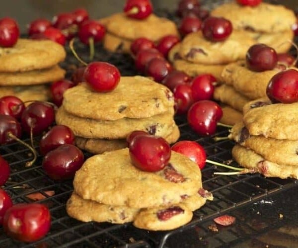 Stacks of cookies with cherries on a cooling rack
