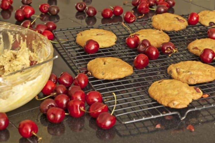 Cookies and bing cherries on a cooling rack