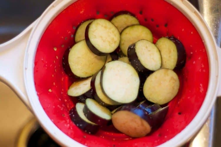 slices of eggplant in a strainer