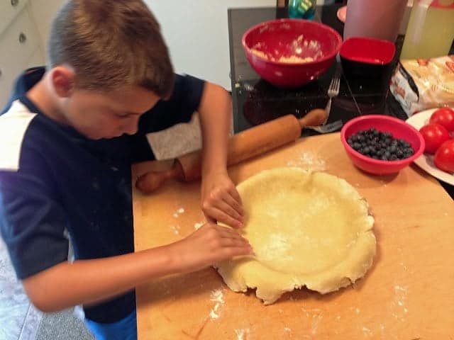 A young boy making a pie