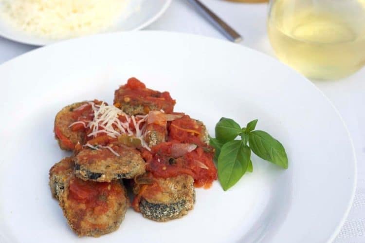 A plate of food on a table, with Eggplant and basil