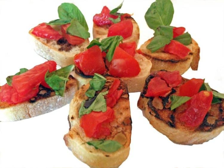 Some small pieces of bread with tomato and basil.