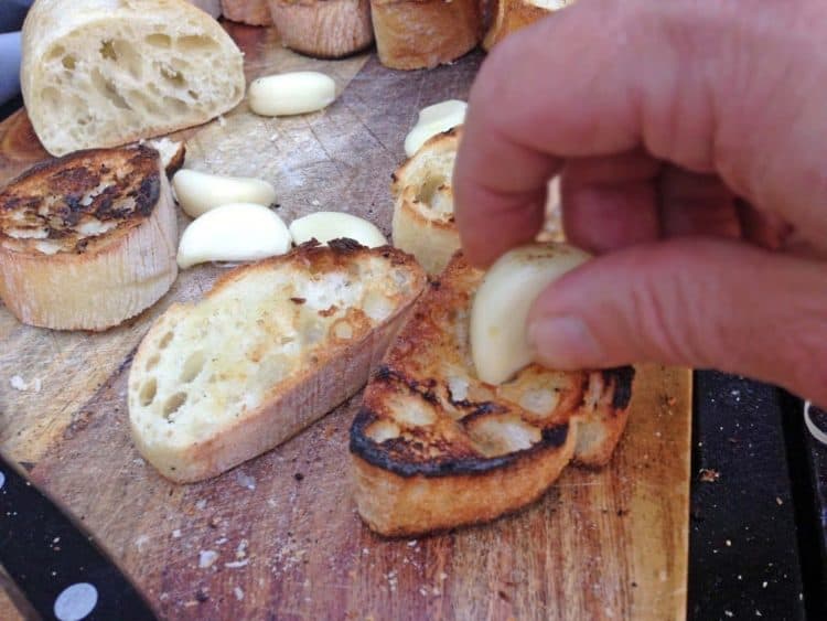Rubbing garlic on toast.