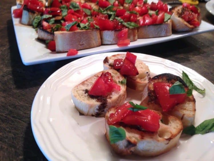 A plate of appetizers of bread and tomato.