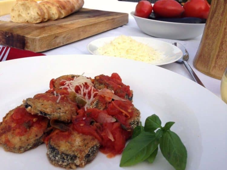 A plate of food on a table, with Eggplant and basil