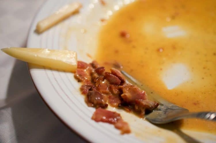 A fork full of sauce and bacon.
