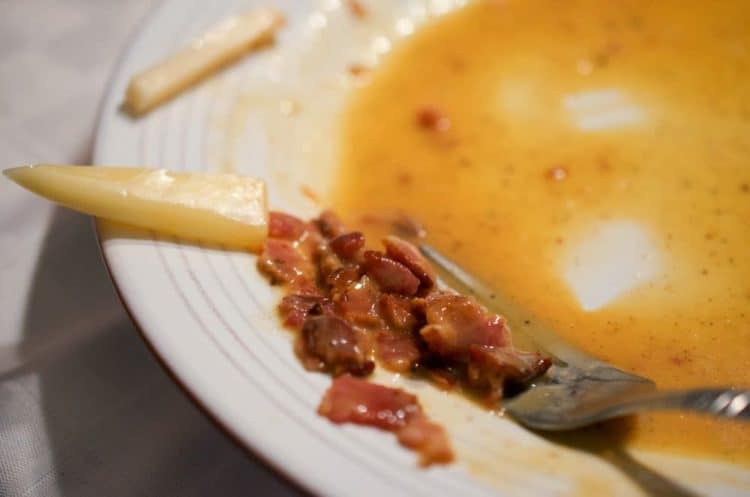 A fork full of sauce and bacon.