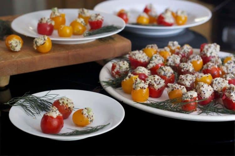 A table with plates of stuffed Cherry tomato.