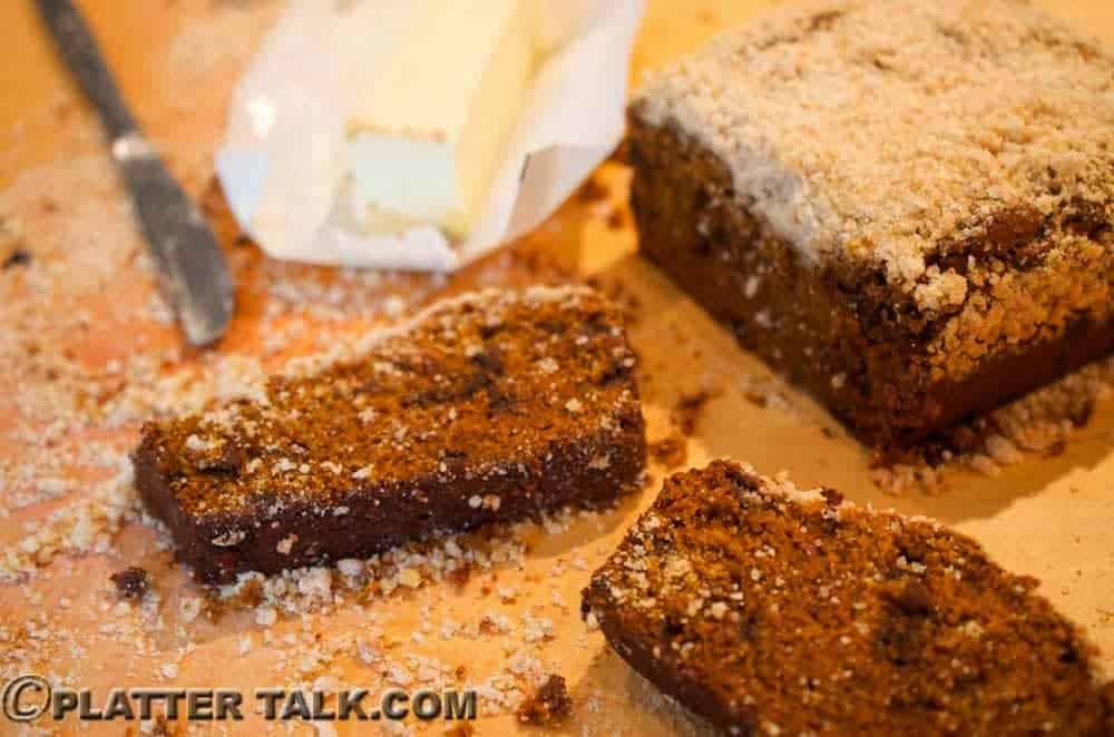 A close up of a piece of pumpkin bread with butter.