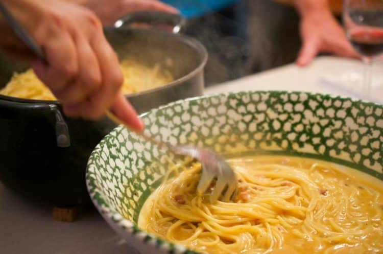 A person serving carbonara.