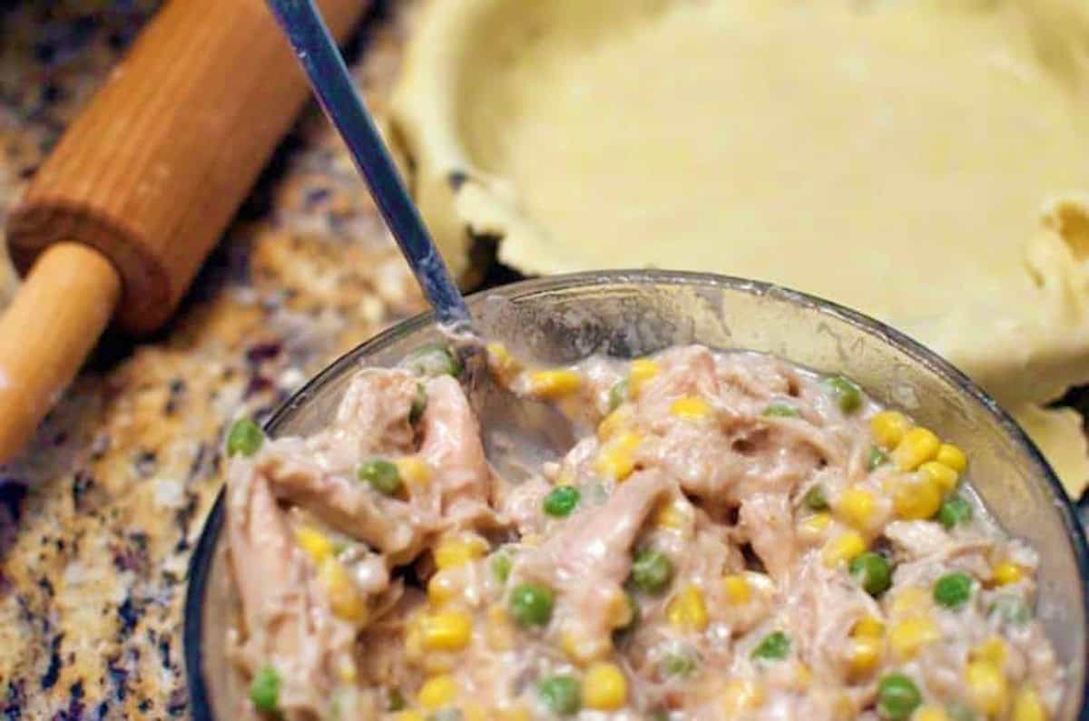 A mixing bowl of shredded chicken for a pot pie filling.