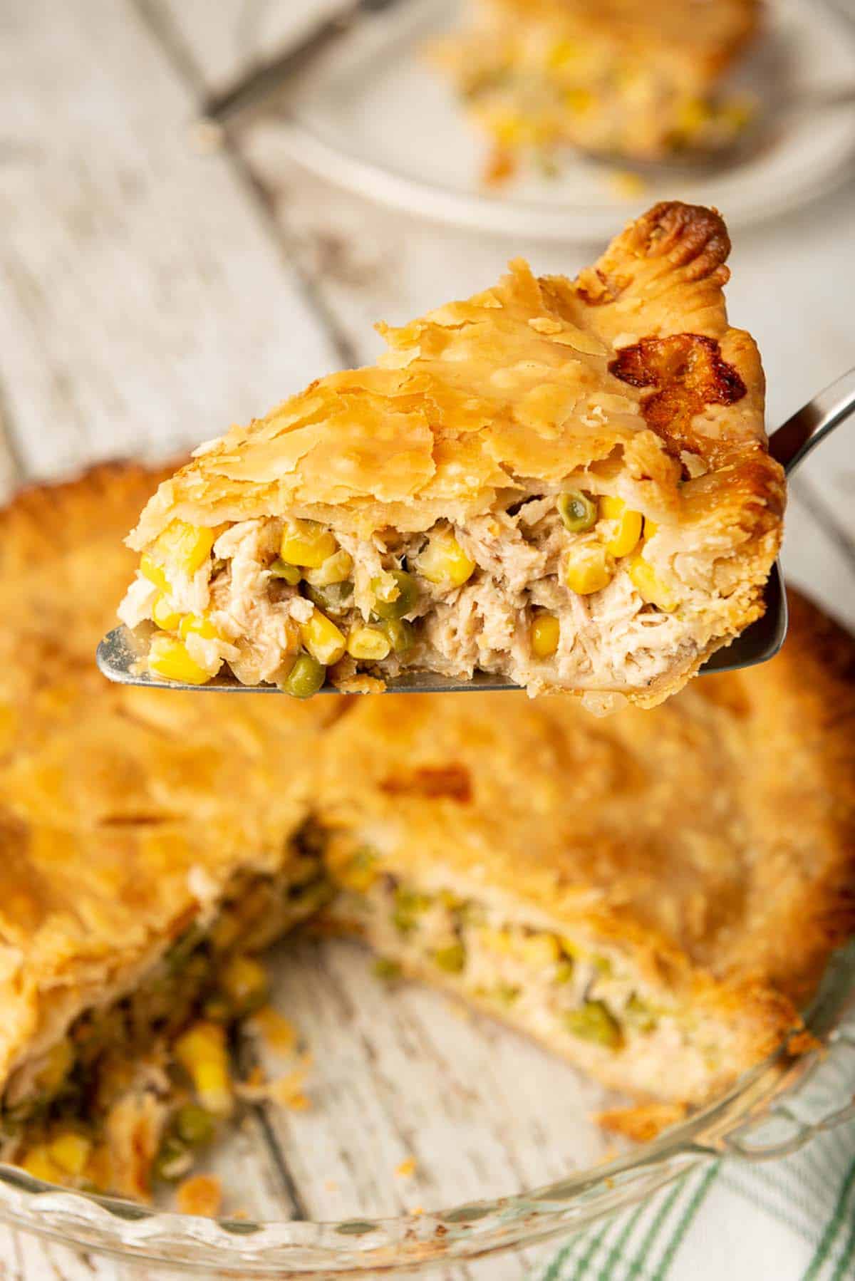 A slice of chicken pot pie being served on a spatula.