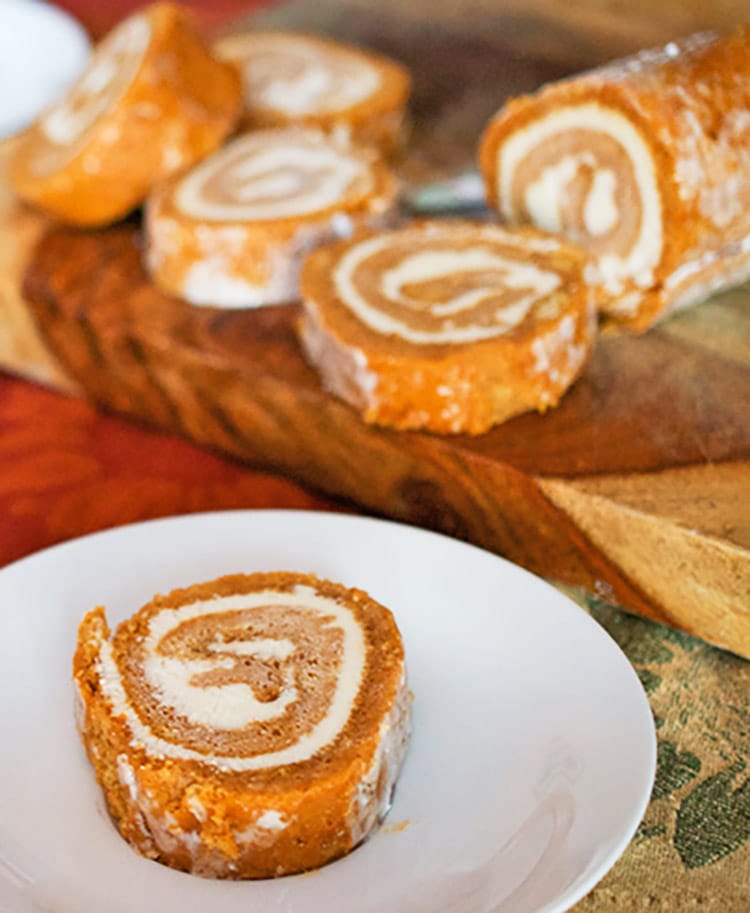 Slice of pumpkin roll cake on a white plate