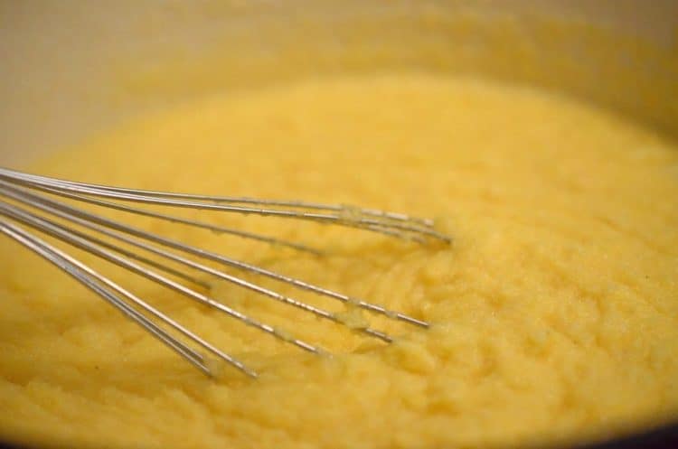 Stirring polenta with a whisk.