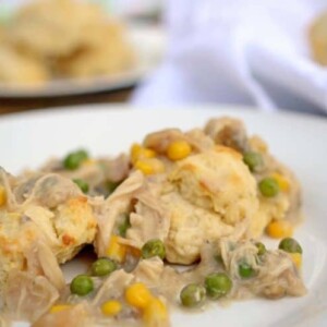 A close up of a plate of chicken and biscuits