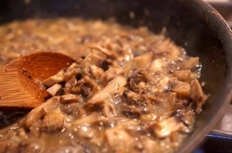 A close up of a pan of mushrooms and sauce.