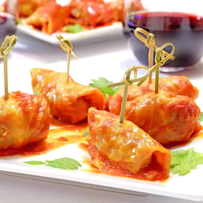 Mini stuffed cabbage with cocktail picks on garnished plate