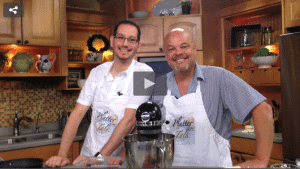 2 men standing behind a mixer, at a kitchen counter