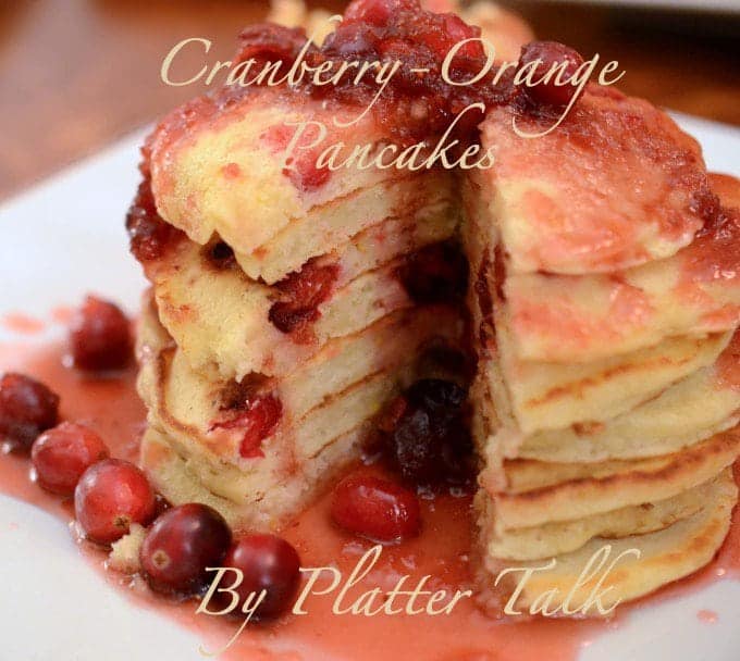 A close up of a stack of Pancakes with cranberries.