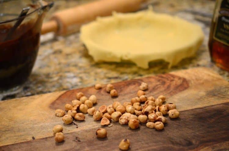 A close up of a pie crust and hazelnuts.