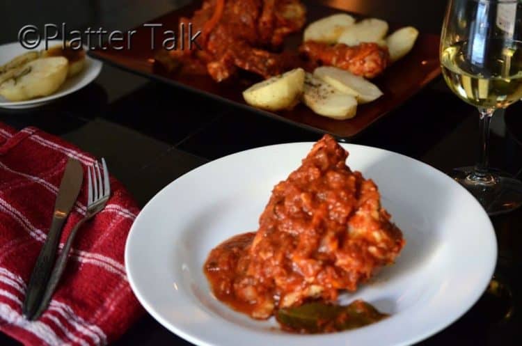 A plate of chicken cacciatore on a table.