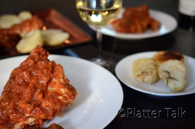 A plate of food on a table, with wine.