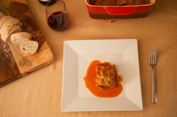 One sauced cabbage roll on plate on table