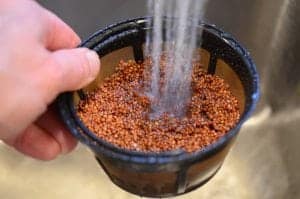 quinoa getting rinsed in a colander 