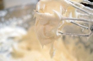 a mixer mixing cake frosting.