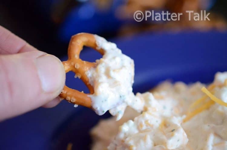 A close up of a pretzel with dip.